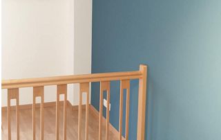 Rampe d'escalier et mur bleu canard