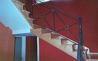 Escalier tournant en bois avec rampe en fer forgé