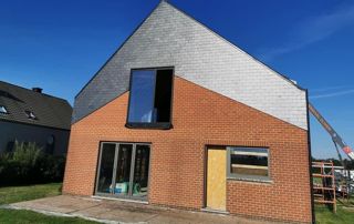 bardage en ardoises sur la façade d'une maison avec toit en pente