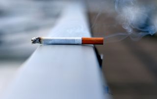 cigarette allumée sur une rambarde