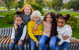 cinq enfants assis sur un banc public