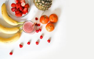 bananes, fraises, mandarines et ananas sur une table