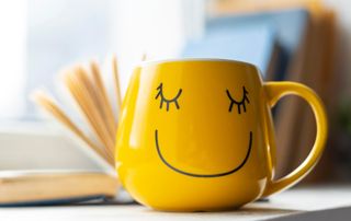 tasse jaune avec un dessin de sourire