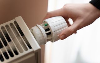 Main sur une vanne de radiateur