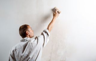 Peintre qui peint un mur