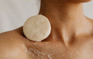 pain de savon sur les épaules d'une femme